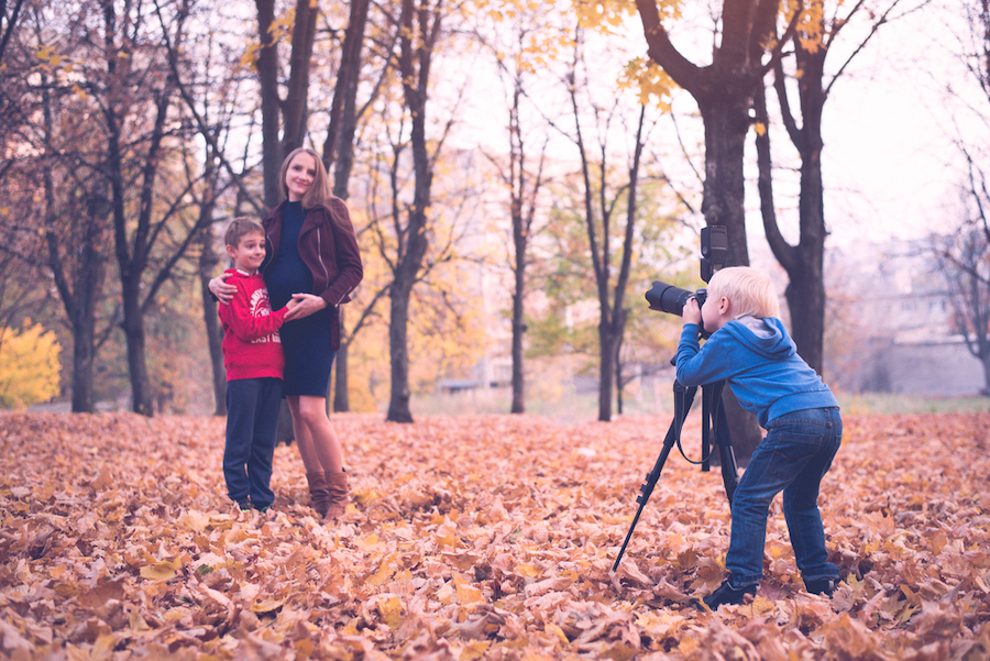 family taking photos together in the woods
